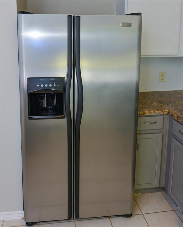 2109 Kimra Lane Cedar Park, TX 78613 - Photo 24 of 31 Kitchen view of stainless steel fridge with ice dispenser, gray cabinets, and dark stone countertops