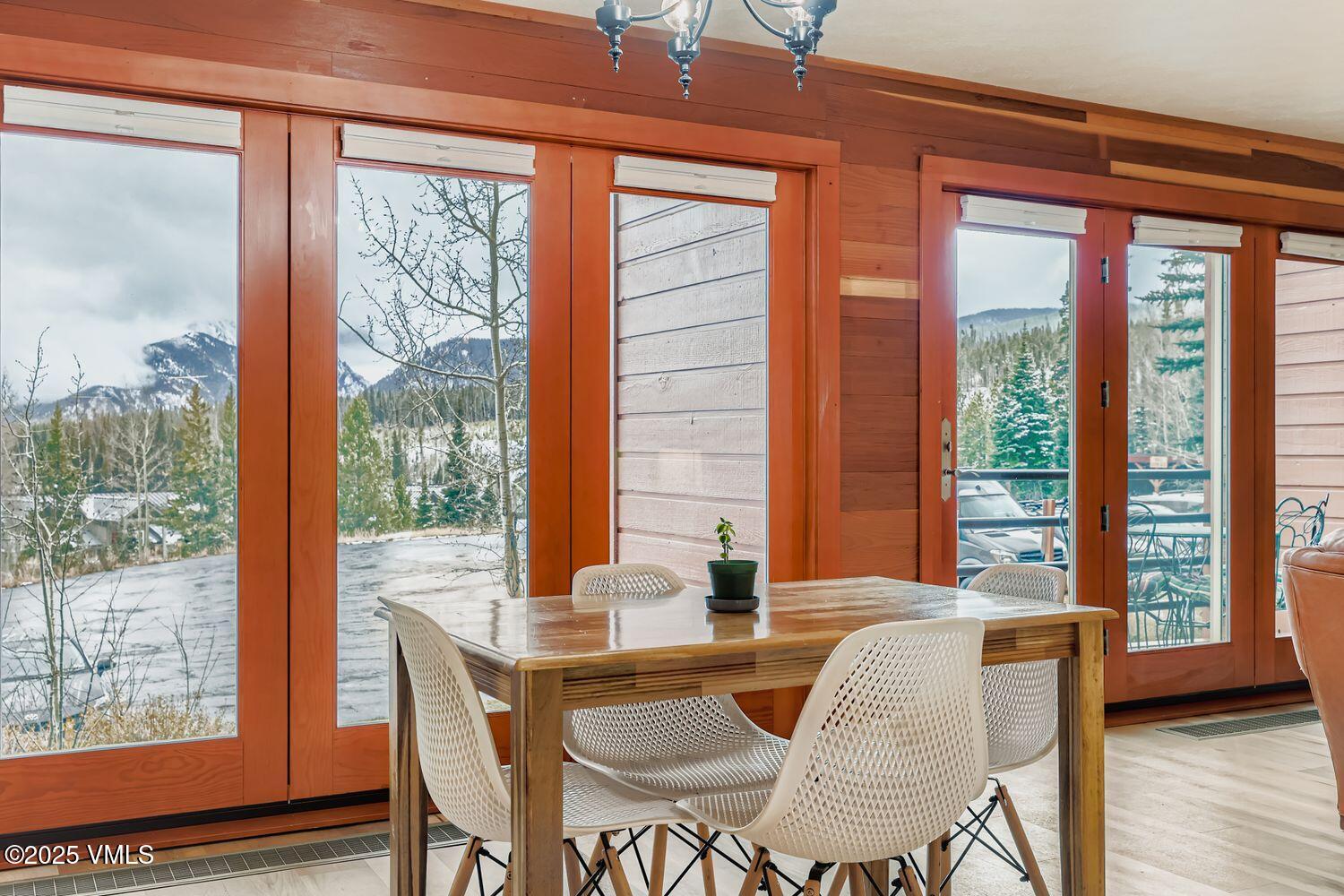 91300 Ryan Gulch Road, Unit 305 Silverthorne, CO 80498 - Photo 11 of 46 a dining room with furniture and large windows