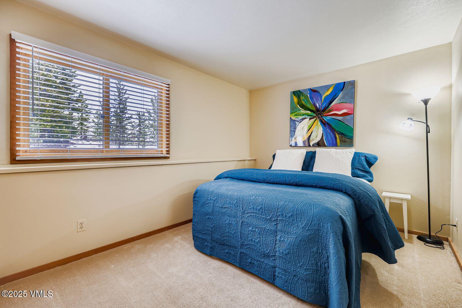 91300 Ryan Gulch Road, Unit 305 Silverthorne, CO 80498 - Photo 19 of 46 a bedroom with a bed and a painting on the wall