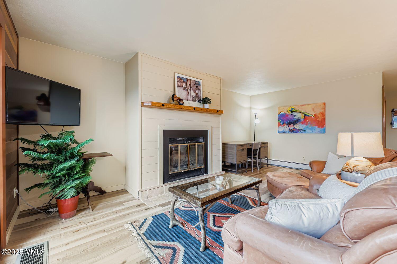 91300 Ryan Gulch Road, Unit 305 Silverthorne, CO 80498 - Photo 5 of 46 a living room with furniture a potted plant and a fireplace