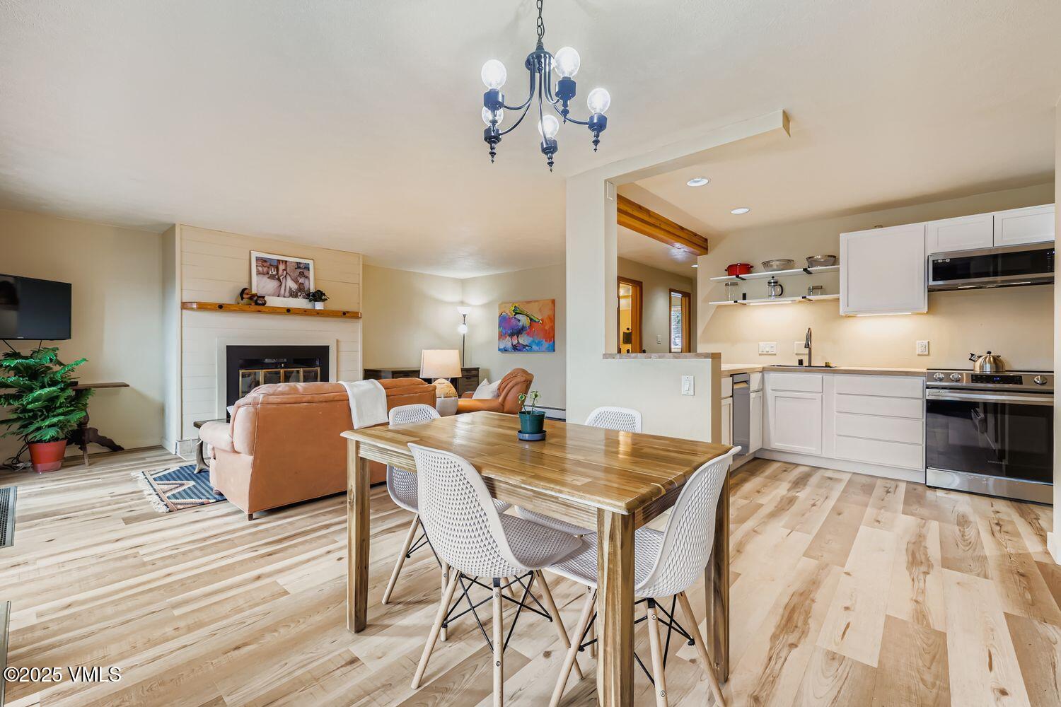 91300 Ryan Gulch Road, Unit 305 Silverthorne, CO 80498 - Photo 8 of 46 a living room with fireplace furniture and a chandelier