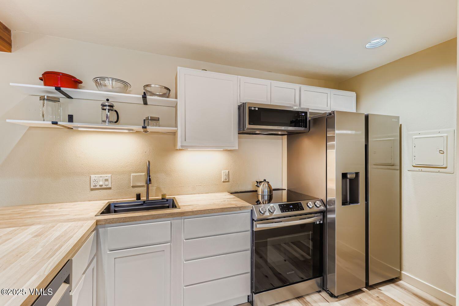 91300 Ryan Gulch Road, Unit 305 Silverthorne, CO 80498 - Photo 9 of 46 a kitchen with stainless steel appliances granite countertop a sink and a refrigerator
