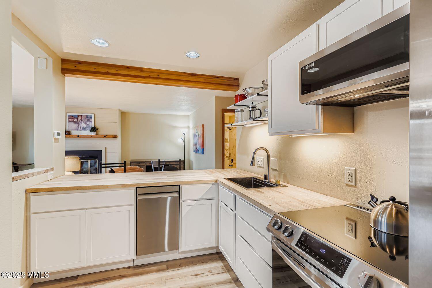 91300 Ryan Gulch Road, Unit 305 Silverthorne, CO 80498 - Photo 10 of 46 a kitchen that has a sink a stove and a microwave