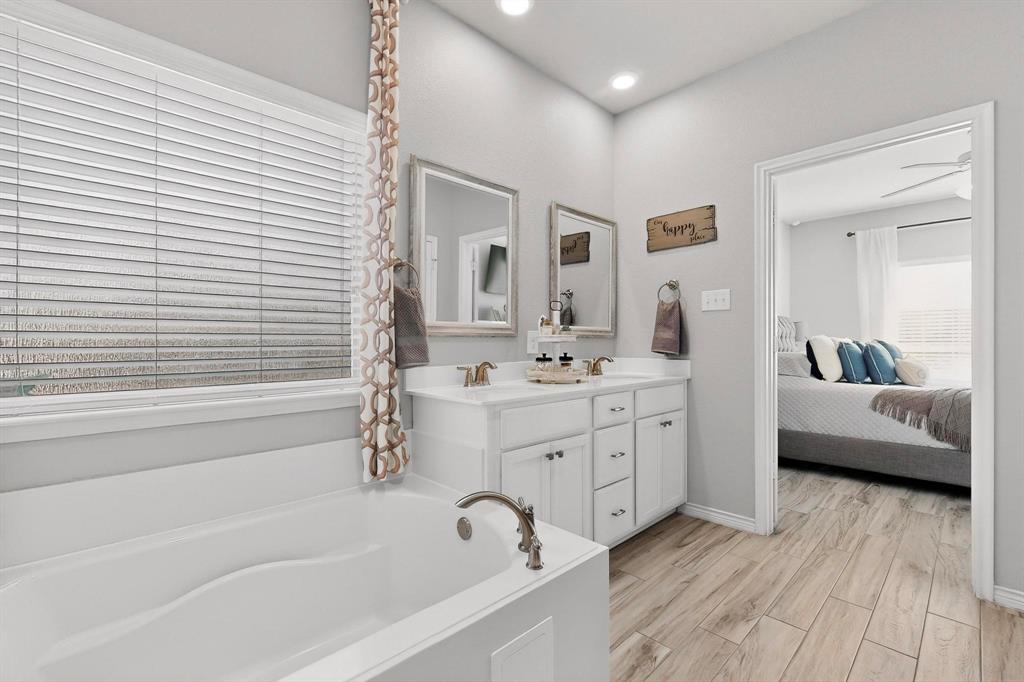 9801 Diamondback McKinney, TX 75071 - Photo 18 of 40 Bathroom with double vanity, a garden tub, ensuite bathroom, wood finish floors, and recessed lighting