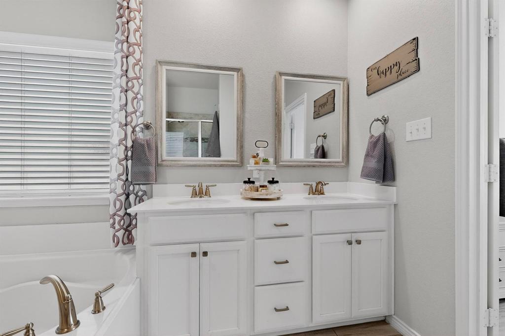 9801 Diamondback McKinney, TX 75071 - Photo 19 of 40 Full bath with double vanity, a garden tub, and an enclosed shower