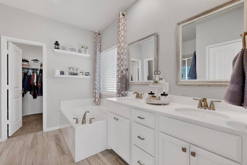 9801 Diamondback McKinney, TX 75071 - Photo 20 of 40 Full bathroom featuring double vanity, a spacious closet, a garden tub, and light wood-style flooring