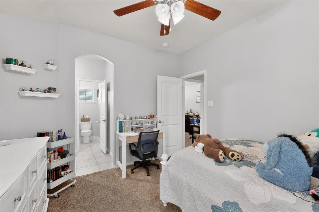 9801 Diamondback McKinney, TX 75071 - Photo 23 of 40 Bedroom with arched walkways, light colored carpet, a ceiling fan, and an office area