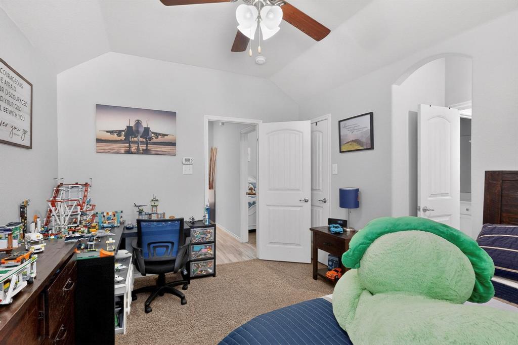 9801 Diamondback McKinney, TX 75071 - Photo 25 of 40 Bedroom featuring vaulted ceiling, light carpet, an office area, ensuite bathroom, and arched walkways