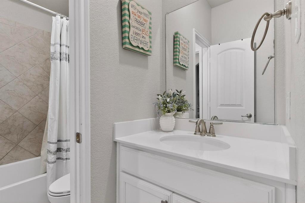 9801 Diamondback McKinney, TX 75071 - Photo 30 of 40 Bathroom with vanity, a textured wall, and shower / bath combination with curtain