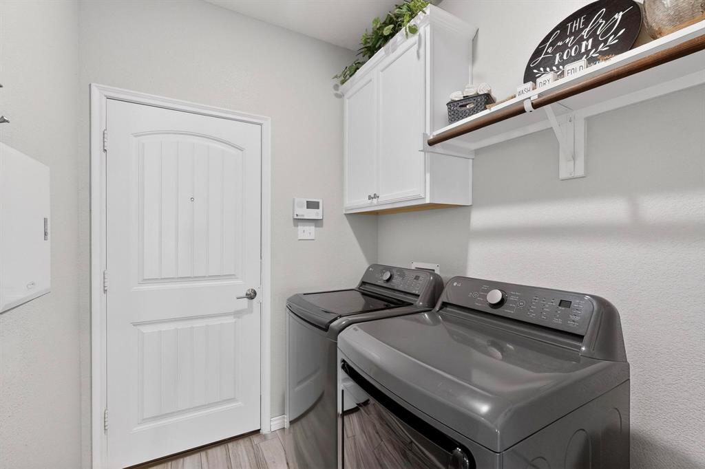 9801 Diamondback McKinney, TX 75071 - Photo 33 of 40 Laundry area featuring cabinet space, washer and dryer, and light wood-style floors