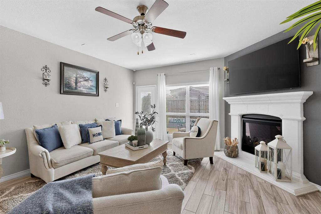 9801 Diamondback McKinney, TX 75071 - Photo 5 of 40 Living room with ceiling fan, wood tiled floors, and a glass covered fireplace