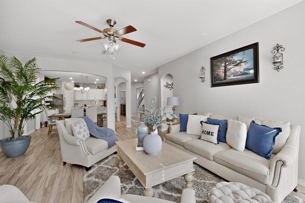 9801 Diamondback McKinney, TX 75071 - Photo 7 of 40 Living area with arched walkways, wood finished floors, ceiling fan, and hanging lights