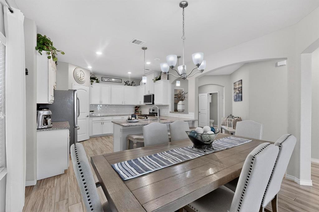 9801 Diamondback McKinney, TX 75071 - Photo 9 of 40 Dining area with hanging lights, arched walkways, and light wood-style flooring