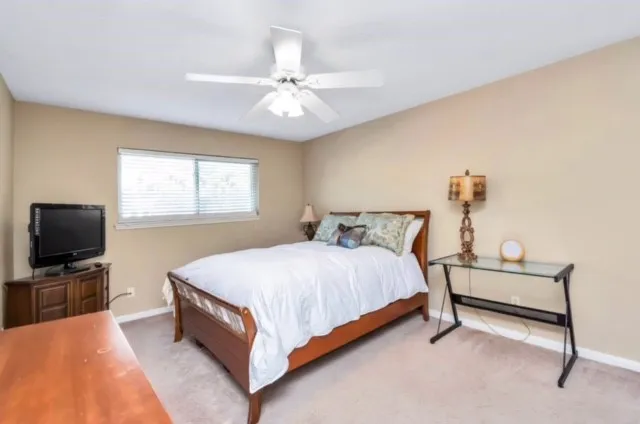 a bedroom with a bed and a flat tv screen on dresser