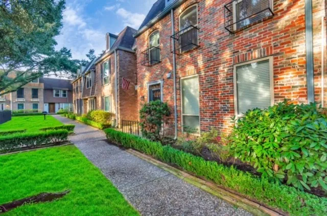 a view of a brick building next to a yard
