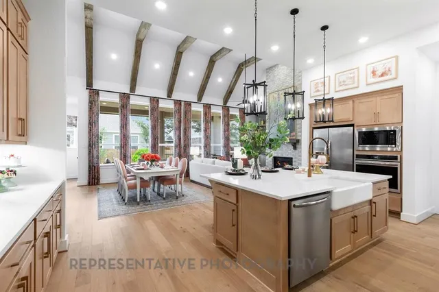 a kitchen with kitchen island a large island in the center windows a sink and a counter top space