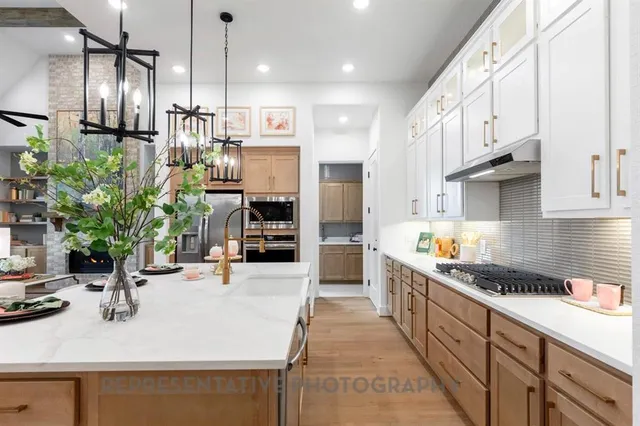 a kitchen with kitchen island granite countertop a sink cabinets and stainless steel appliances