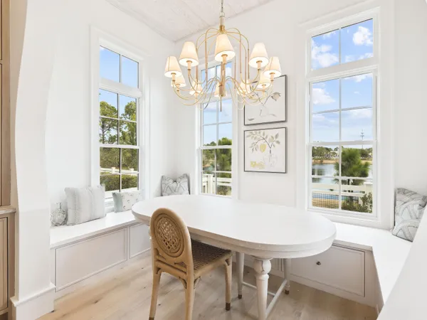 a dining room with furniture a chandelier and wooden floor