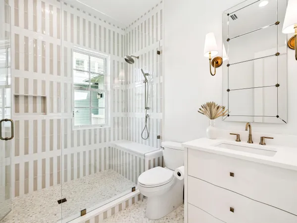 a bathroom with a sink toilet a shower and a mirror