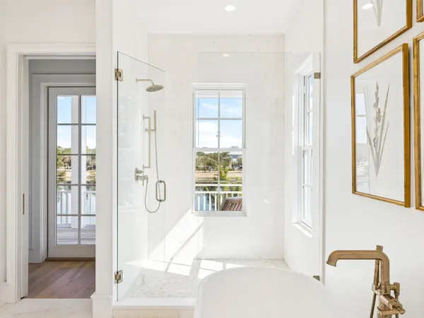 a bathroom with a tub shower and windows
