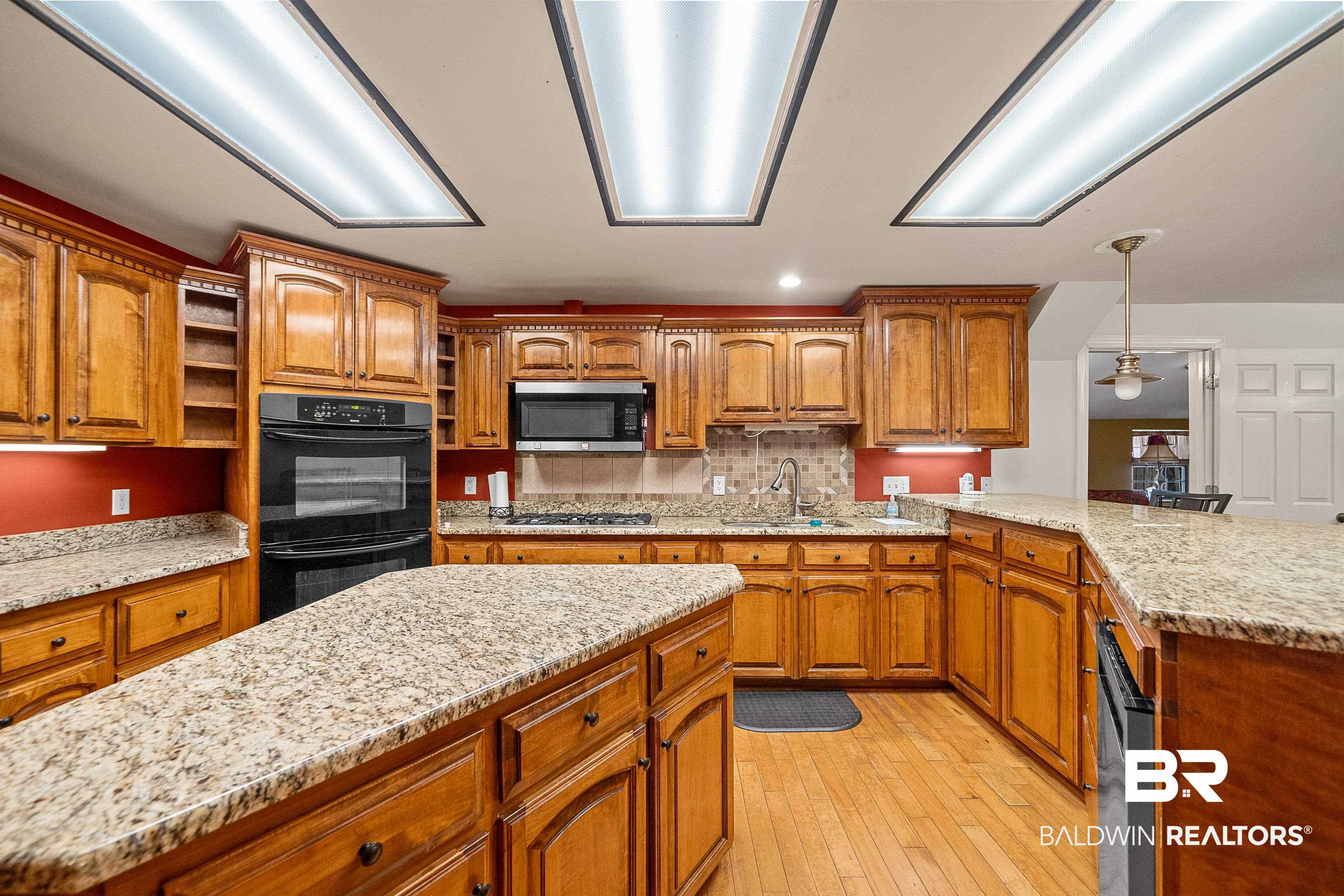 11528 Whitehouse Fork Road Bay Minette, AL 36507 - Photo 13 of 37 Kitchen with brown cabinetry, light stone counters, pendant lighting, tasteful backsplash, and recessed lighting