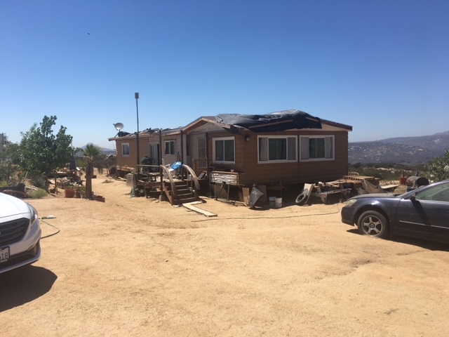 1388 Harris Ranch Road Potrero, CA 91963 - Photo 22 of 24 a front view of a house with a yard
