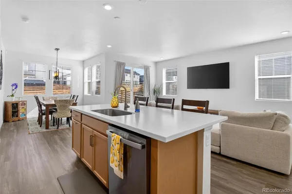 a living room with furniture a flat screen tv and kitchen view