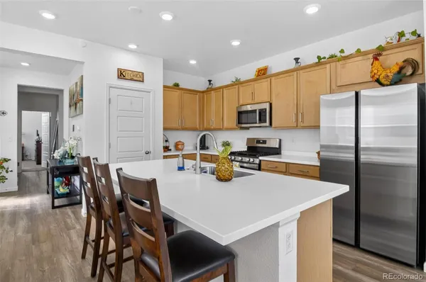 a kitchen with a refrigerator a stove a microwave a dining table and chairs