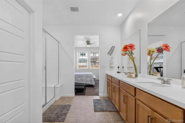 a bathroom with a double vanity sink mirror and shower