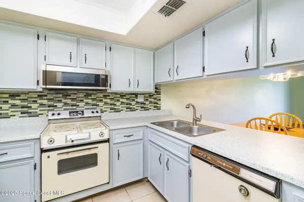 a kitchen with stainless steel appliances a stove a sink and a microwave