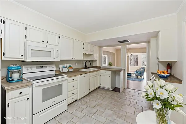 a kitchen with granite countertop white cabinets and white appliances