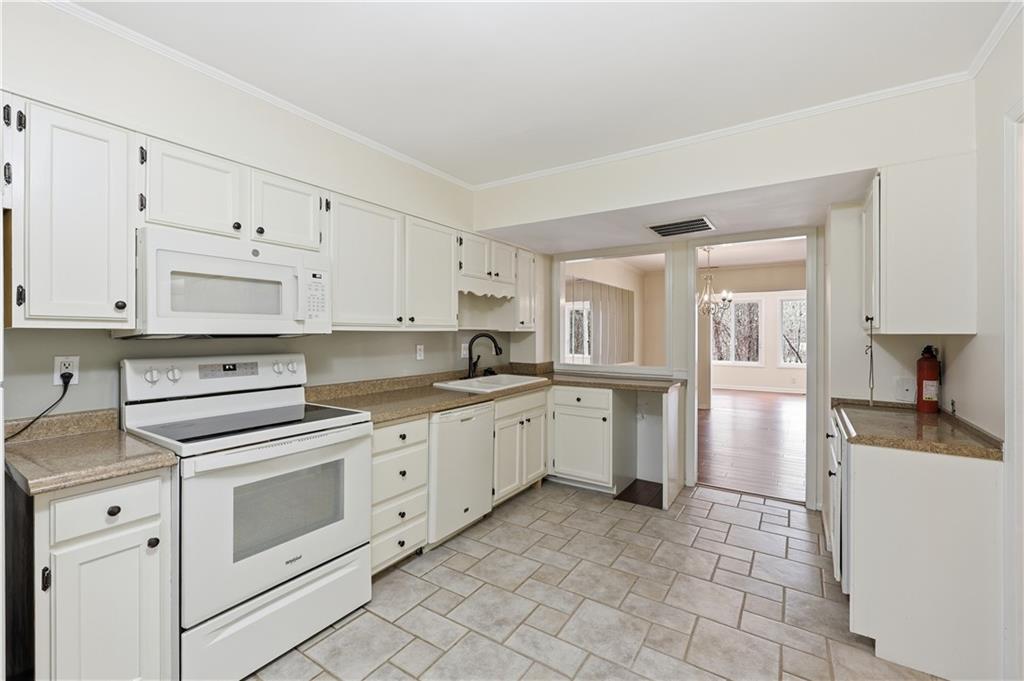 6500 Gaines Ferry Road, Unit I4 Flowery Branch, GA 30542 - Photo 20 of 29 a kitchen with granite countertop white cabinets and white appliances