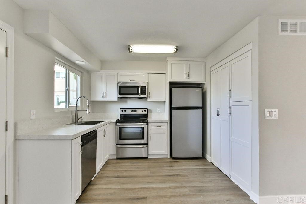 10022 Great Rock Road Santee, CA 92071 - Photo 11 of 32 a kitchen with cabinets stainless steel appliances a sink and a window