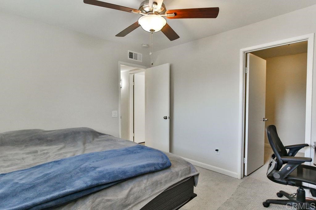 10022 Great Rock Road Santee, CA 92071 - Photo 15 of 32 a bedroom with a bed and a chandelier