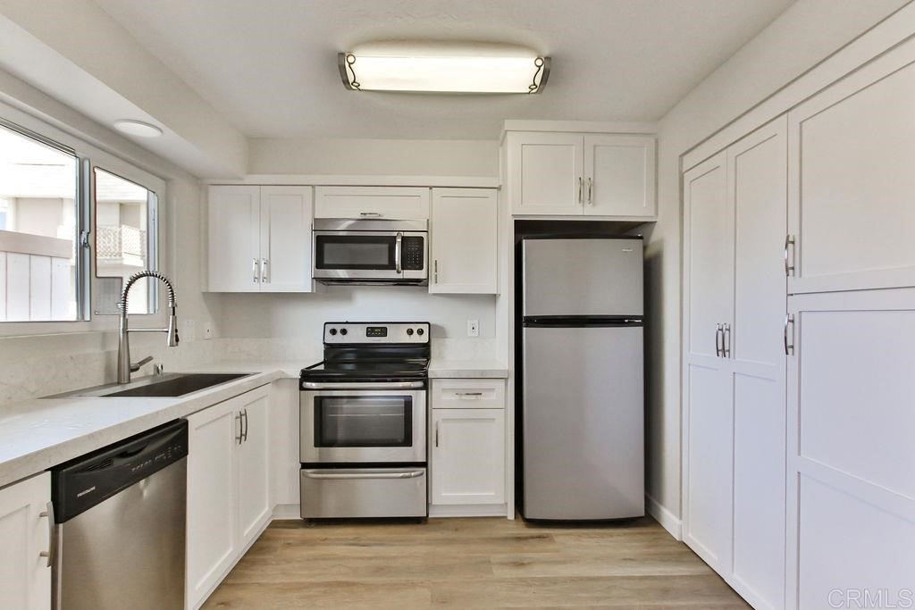 10022 Great Rock Road Santee, CA 92071 - Photo 3 of 32 a kitchen with a refrigerator sink and wooden floor