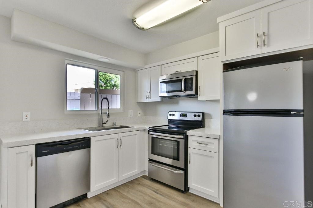 10022 Great Rock Road Santee, CA 92071 - Photo 9 of 32 a kitchen with stainless steel appliances a sink cabinets and a window