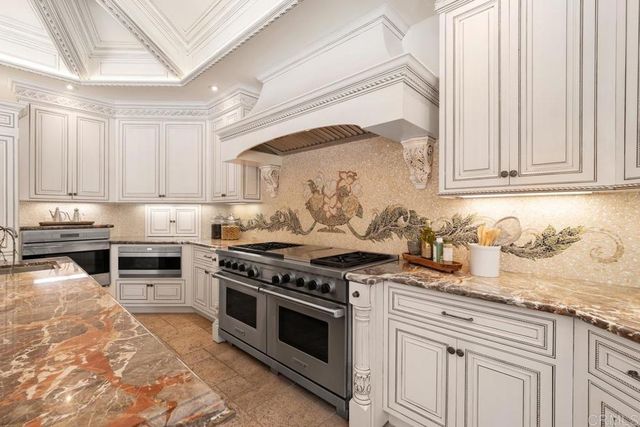a kitchen with granite countertop a sink a counter top space appliances and cabinets
