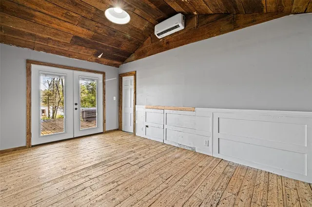 a view of an empty room with closet and windows