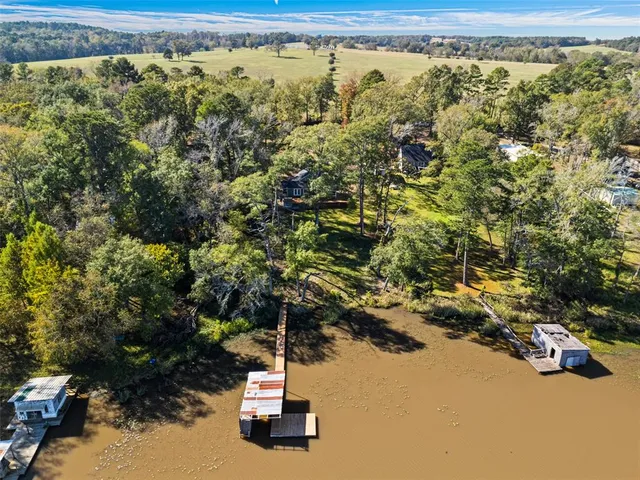 a view of a lake with a bench and trees