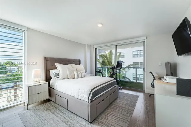 a bedroom with a bed and large windows