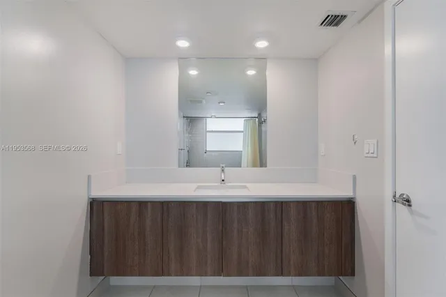 a bathroom with a sink a mirror and a shower