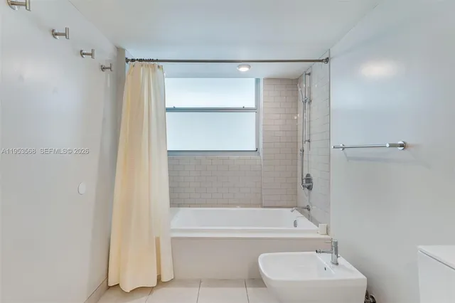 a bathroom with a bathtub shower sink vanity and toilet