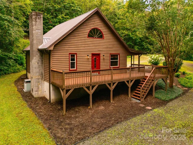 a view of a house with a yard chairs and floor to ceiling window