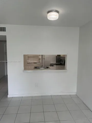 a view of kitchen and an empty room