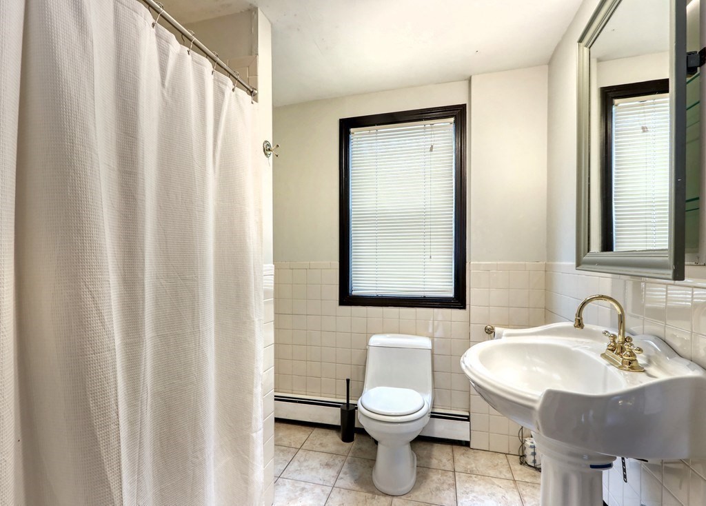 12 Jenkins Street Boston, MA 02127 - Photo 11 of 16 a bathroom with a toilet a sink and a mirror