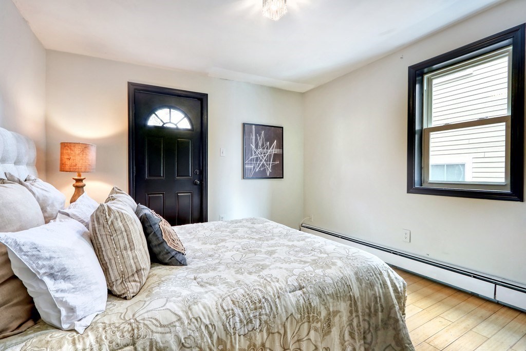 12 Jenkins Street Boston, MA 02127 - Photo 8 of 16 a bedroom with a bed and lamp with window