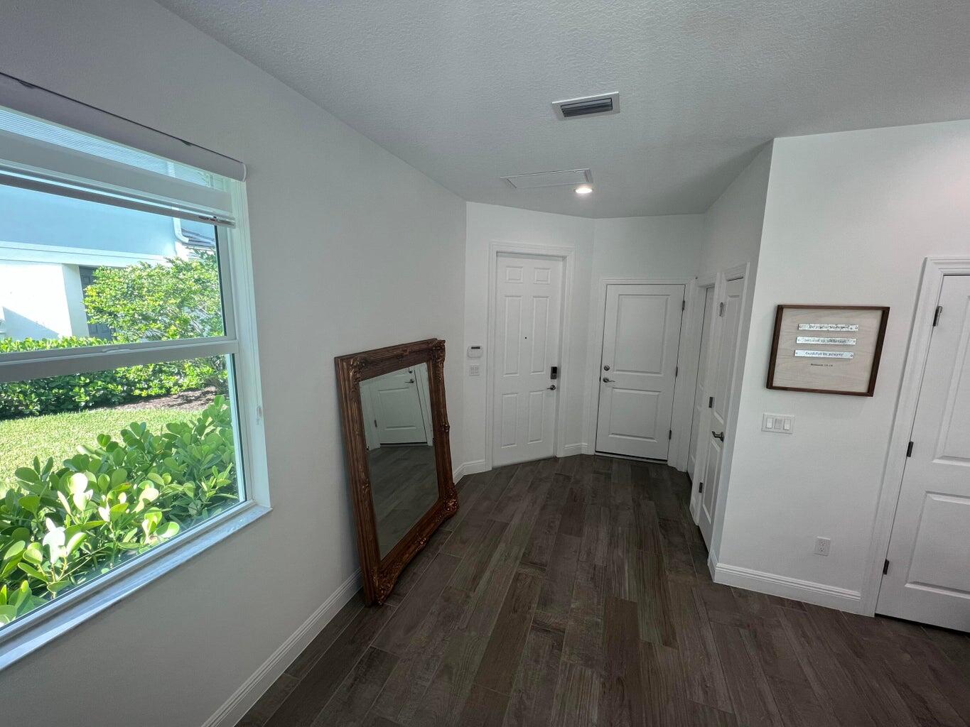 562 Parsons Way Deerfield Beach, FL 33442 - Photo 3 of 15 a view of hallway with a large window and wooden floor