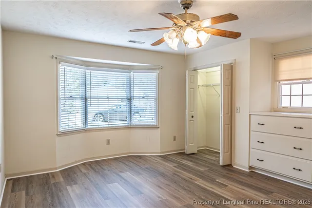 a view of an empty room with a window and a dresser