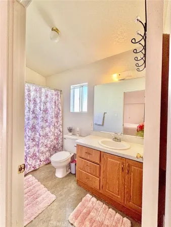 a bathroom with a granite countertop sink mirror vanity and toilet