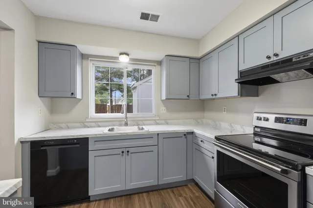 a kitchen with a sink stove and cabinets